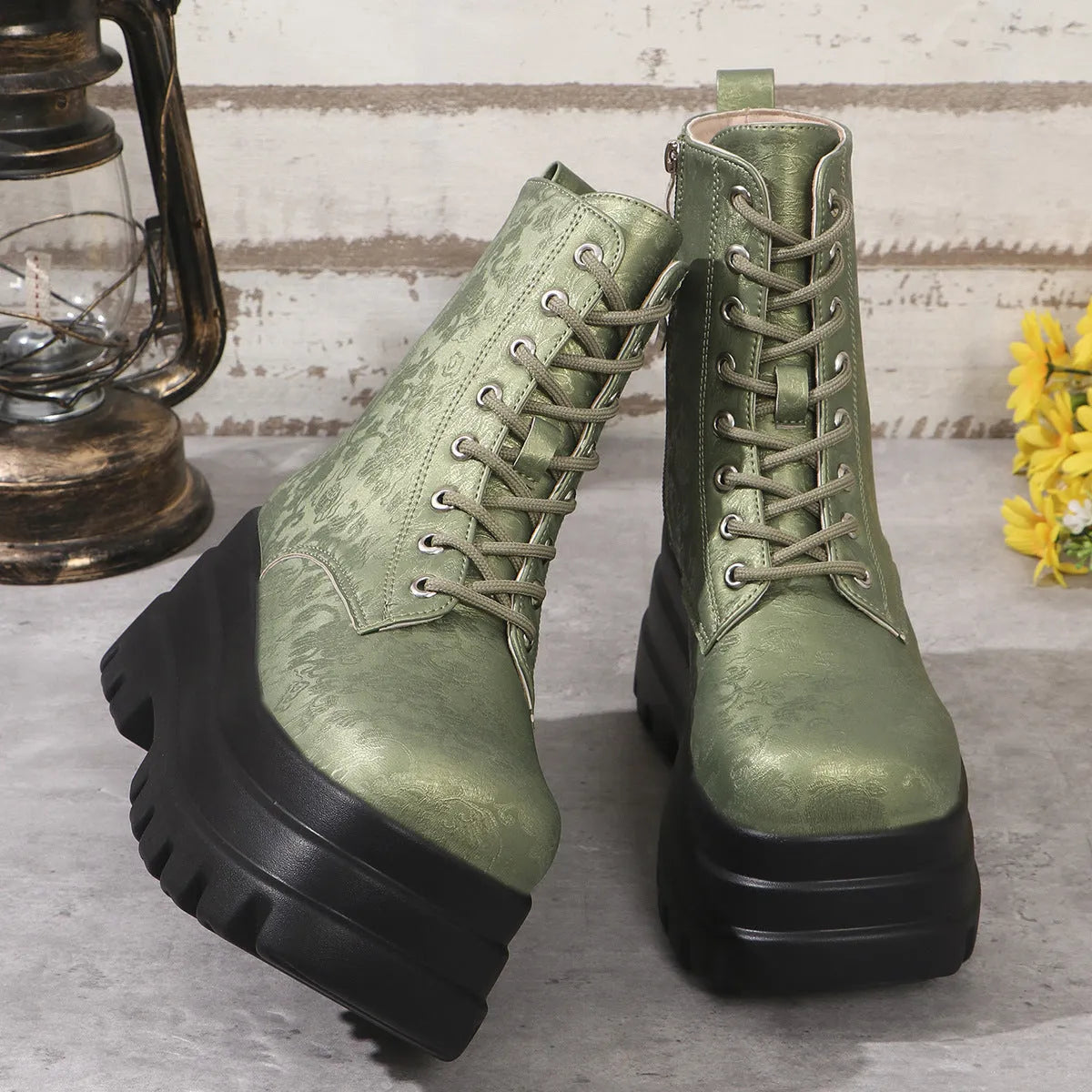 Women's black platform Martin boots with chunky heel and side zipper on a wooden floor