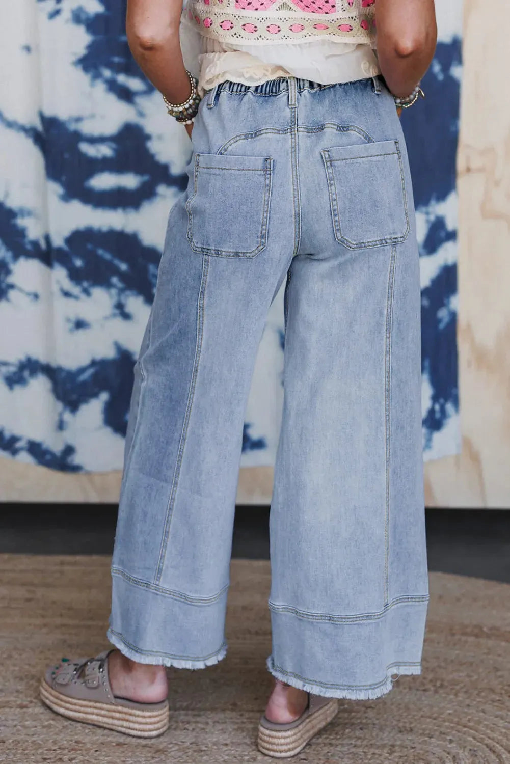 Beau blue wide leg denim pants with drawstring waist and raw hem detail laid flat