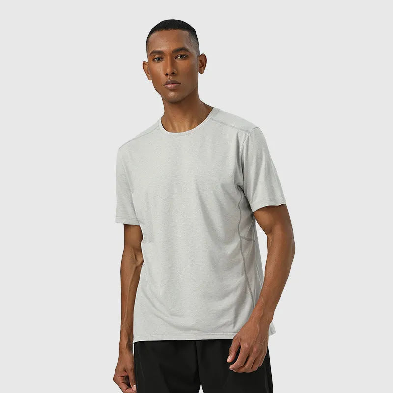 Man wearing a lightweight dark gray short sleeve sports top with reflective details on the sleeves.