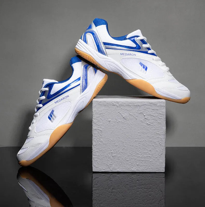 White and red table tennis sneakers with synthetic leather upper and lace-up front.