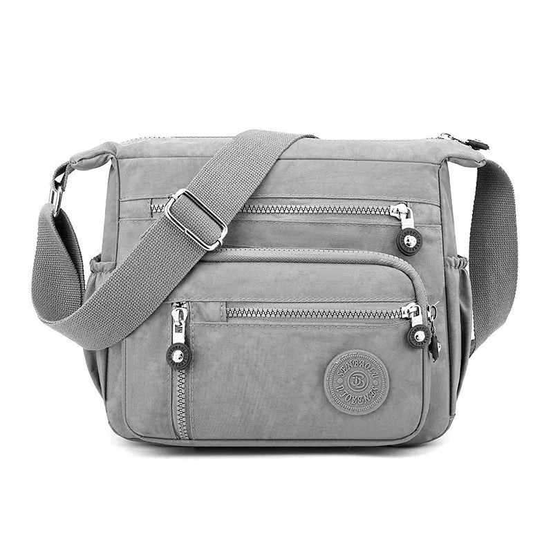 Nylon messenger bag in dark blue with single shoulder strap and soft square design, showing lining cloth interior.