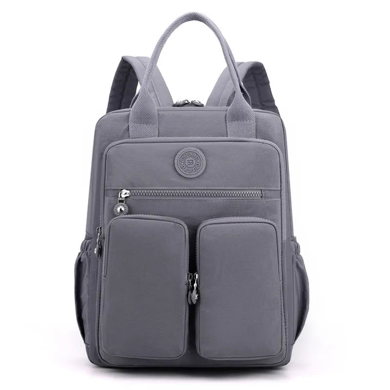 Large purple waterproof travel backpack showing front organiser pocket and internal laptop and camera compartments.