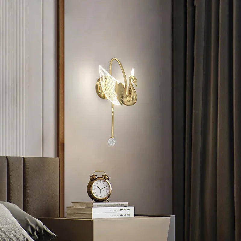 Gold swan-shaped wall lamp with acrylic shade and iron body, mounted beside bed with adjustable LED lighting