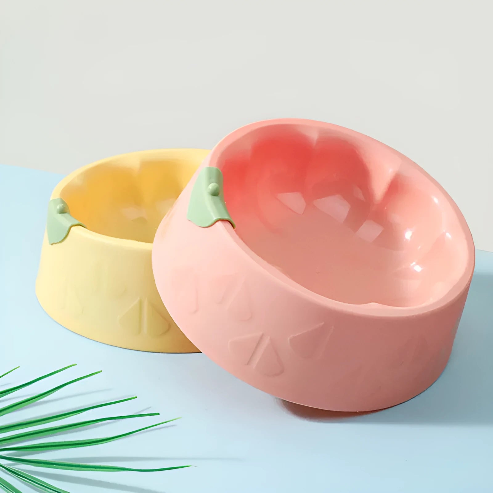 Flower-shaped green plastic double pet bowl for cat and dog food and water on a white surface.