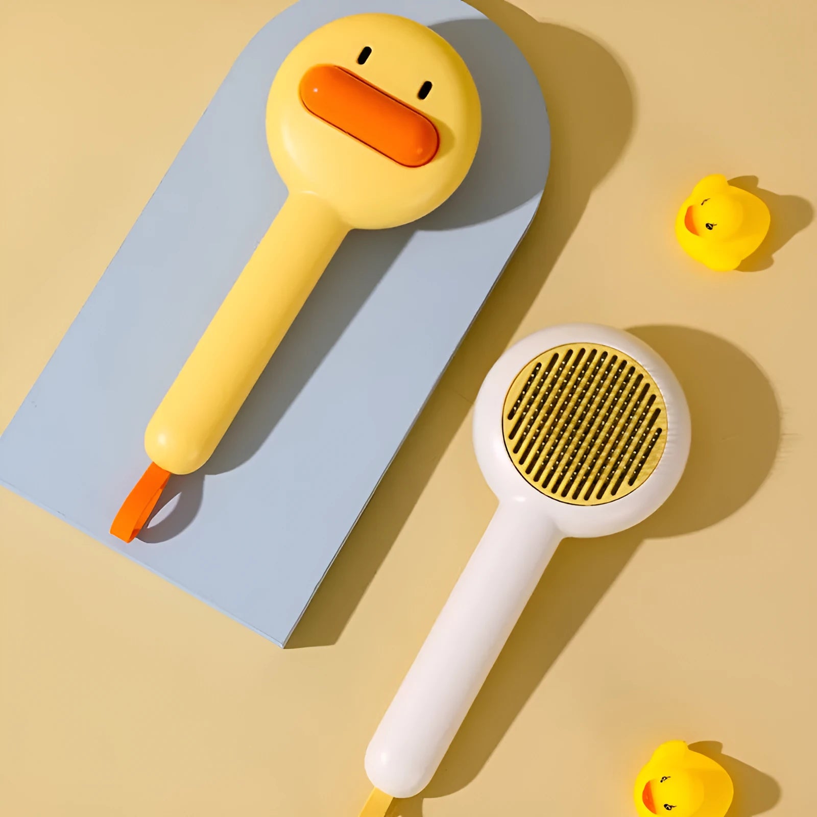 Small yellow duck-shaped comb for pet grooming with open section and needle bristles
