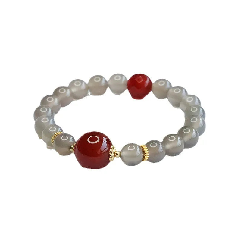 Natural smoky purple and red agate bracelet with 8mm geometric beads on a wrist.