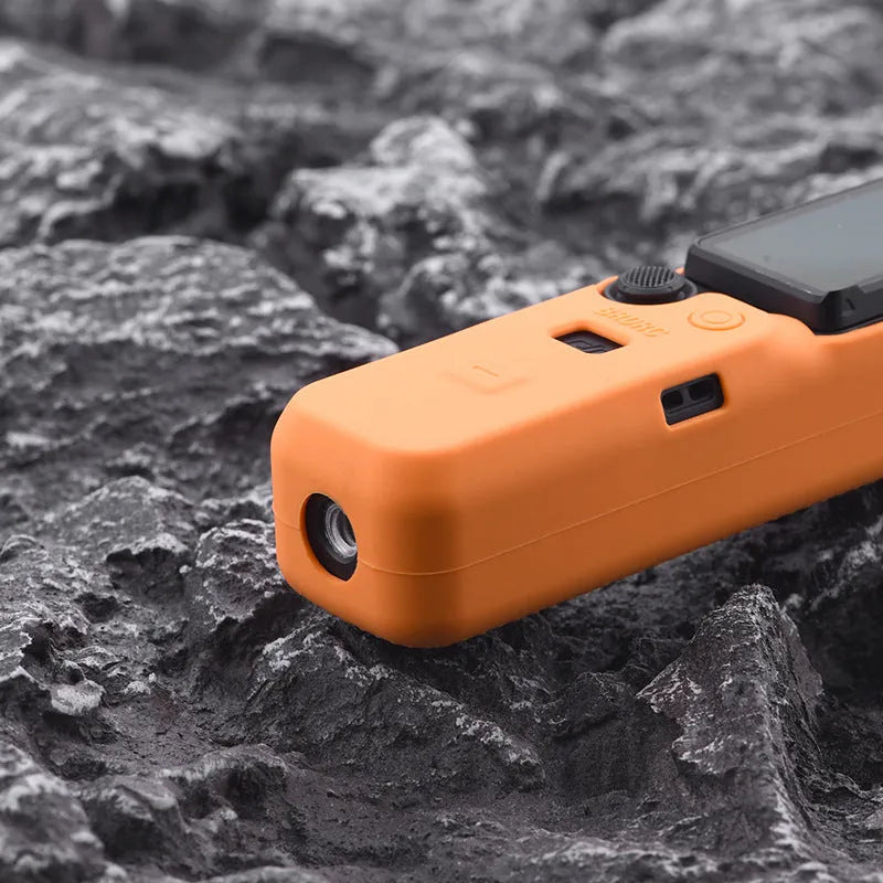 Black silicone protective sleeve for a PTZ camera body, shown alongside red and orange versions.
