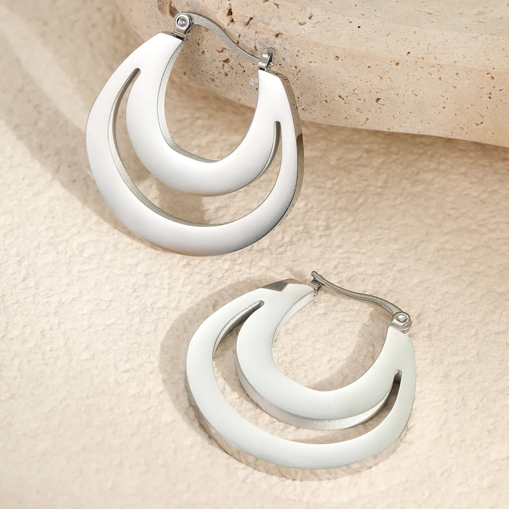 A pair of geometric minimalist French earrings in a round ring design, shown in both gold and steel metallic finishes.