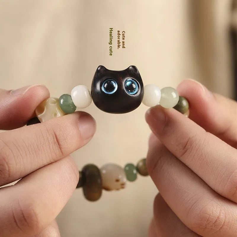 Hand-woven beaded bracelet with a cat's paw charm, multi-treasure cube, and mix of jade and wood beads.