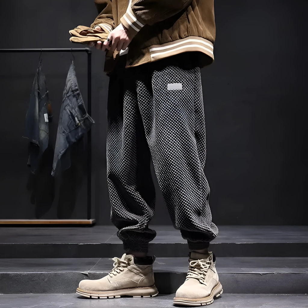 Man wearing grey ankle-tie sweatpants, showing the straight leg and adjustable cuff detail.