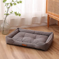 Grey raised cushion dog sofa bed with a waterproof Oxford cloth cover on a wooden floor.