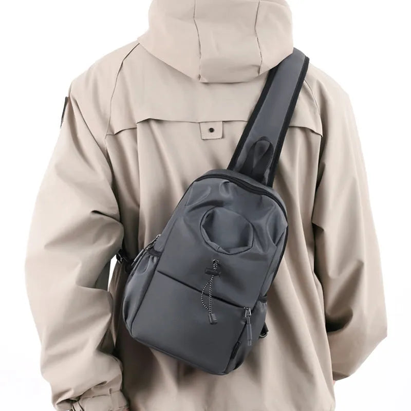 Dark grey Oxford cloth crossbody chest bag with stitching detail, shown being worn.