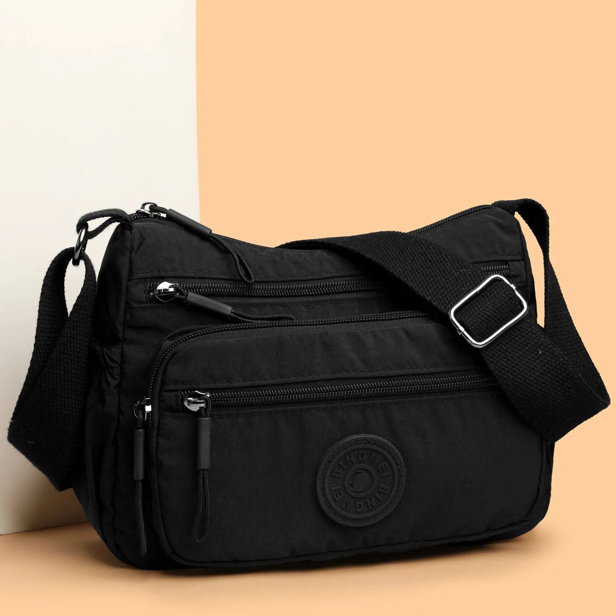Soft water-repellent nylon crossbody bag in grey with a front 3D pocket.