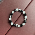 Close-up of a 10mm natural opal and black agate beaded bracelet in a Tai Chi style.
