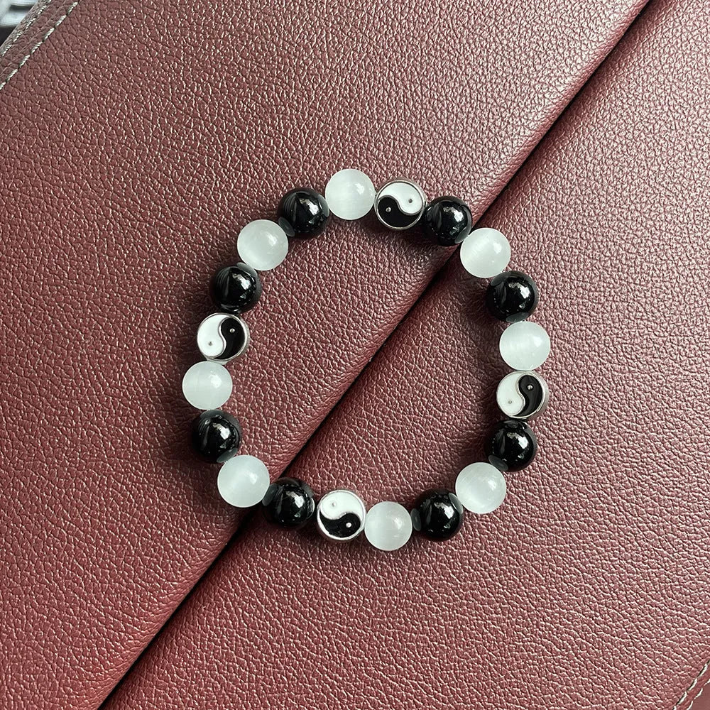 Close-up of a 10mm natural opal and black agate beaded bracelet in a Tai Chi style.