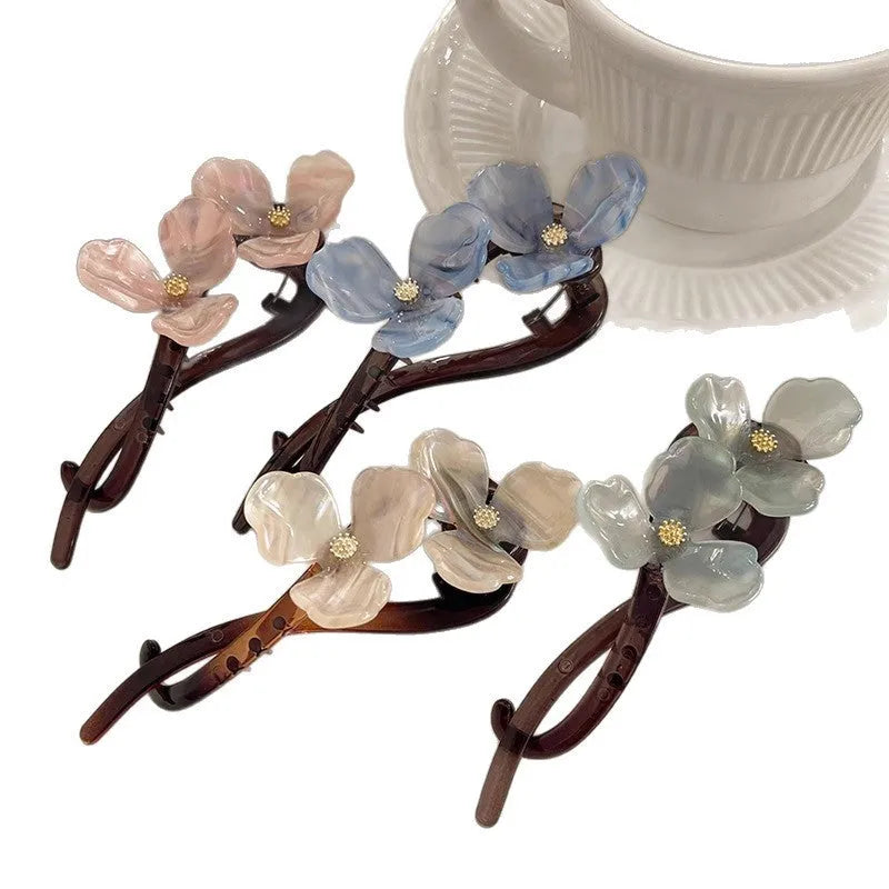 Retro flower hair bobby pin with coloured acrylic petals on a white background.