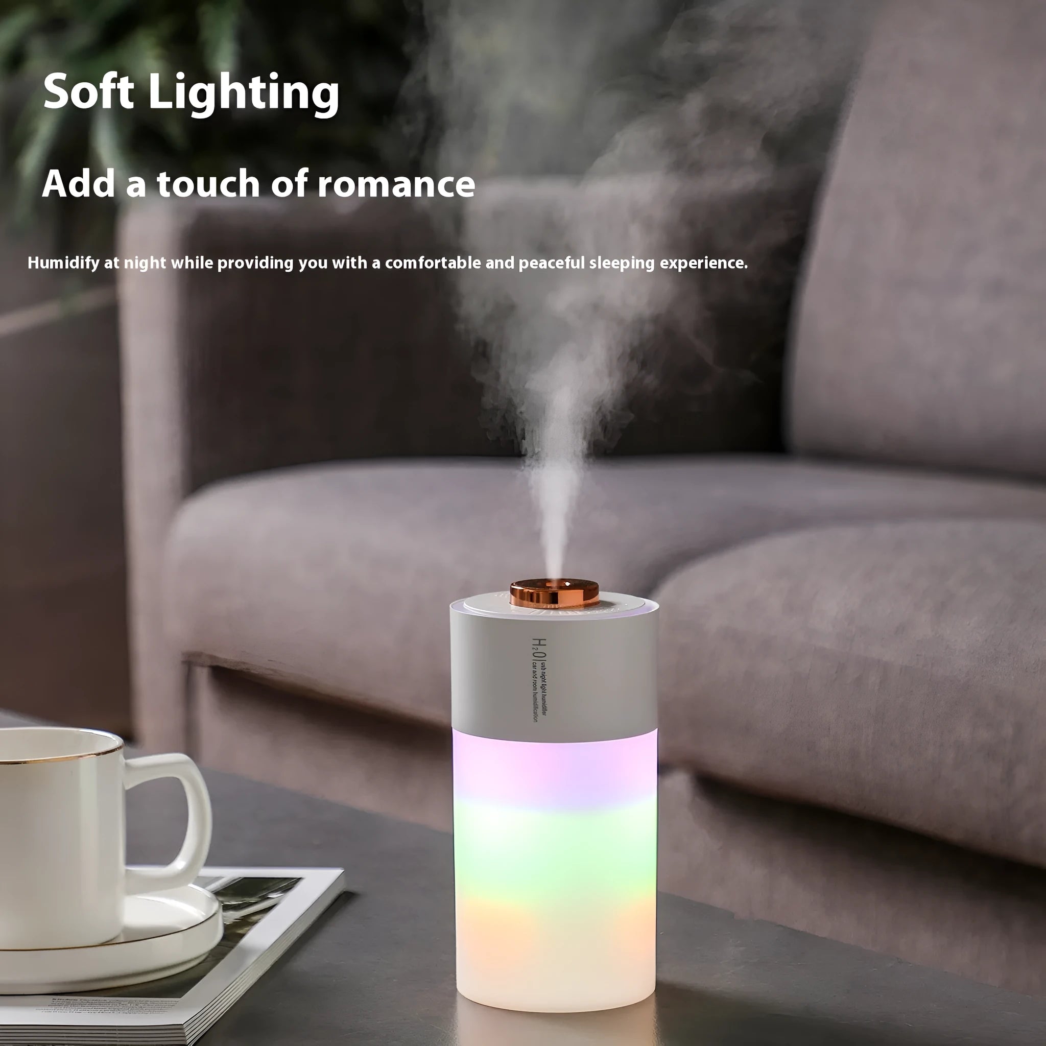 Pink column-shaped USB desk humidifier with colourful LED mist on a wooden surface.