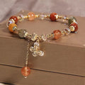 Colour hair crystal cat's paw charm bracelet with zircon butterfly on wrist.