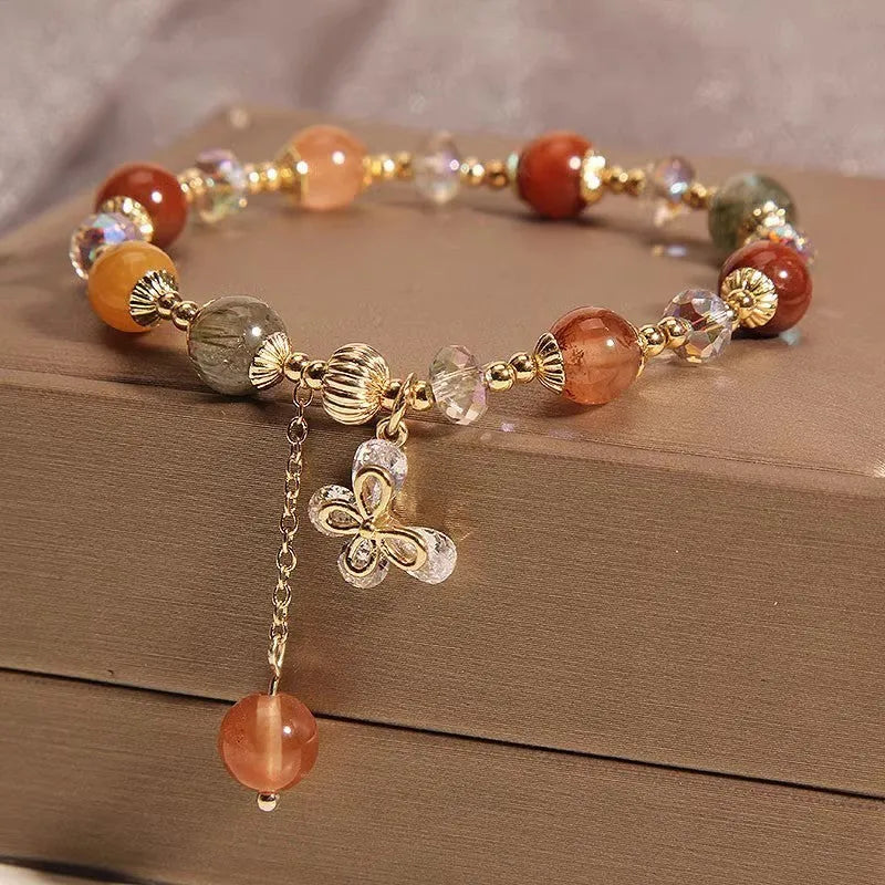 Colour hair crystal cat's paw charm bracelet with zircon butterfly on wrist.