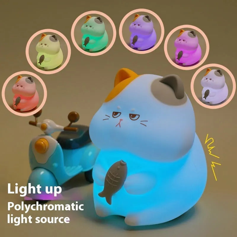 Small yellow Greedy Cat cartoon desktop night light with socket plug on desk.