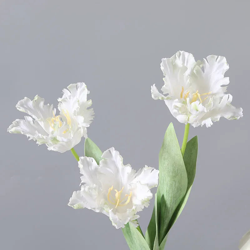Artificial toothed tulip fake flower arrangement in bright red colour on wooden table
