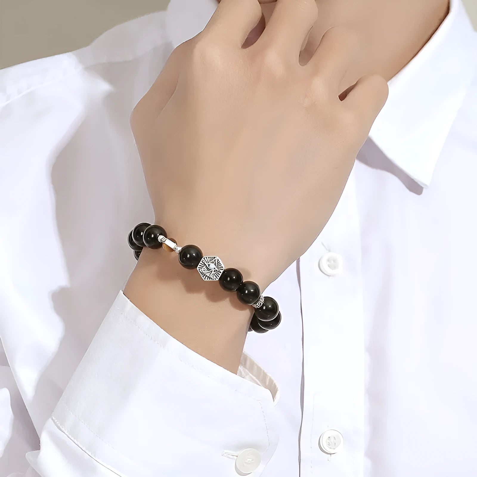Men's S925 sterling silver bracelet with an 8mm geometric obsidian God's Eye centrepiece on a wrist.