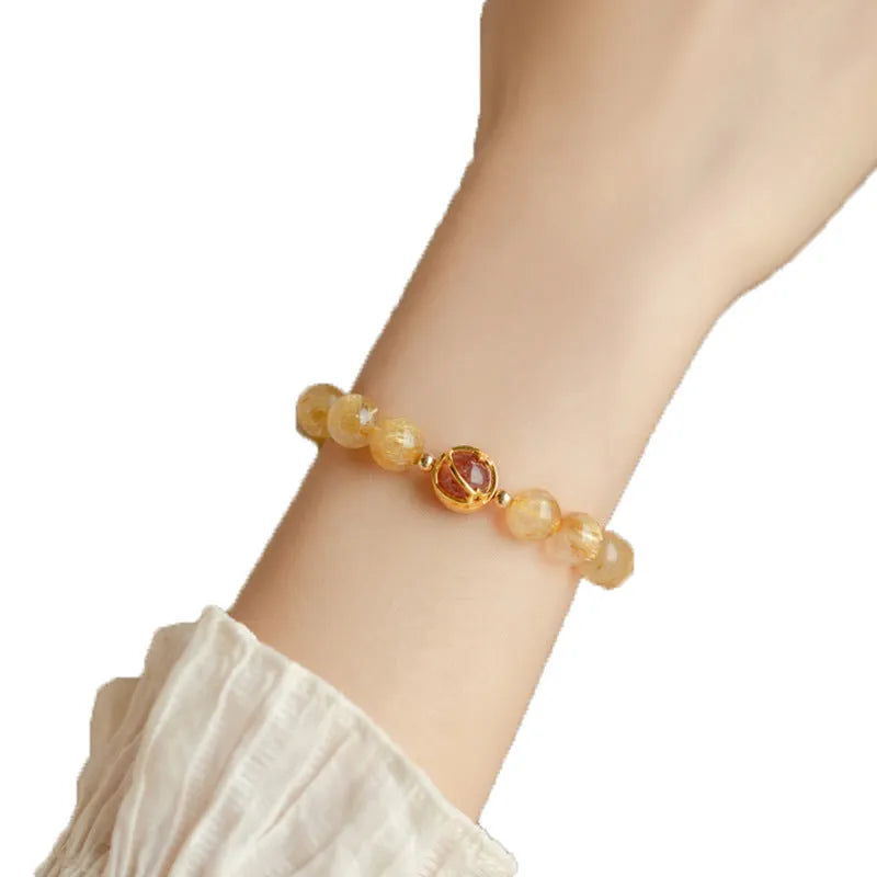 Gold rutilated quartz crystal bracelet with diamond-cut beads on stretch cord in Korean style
