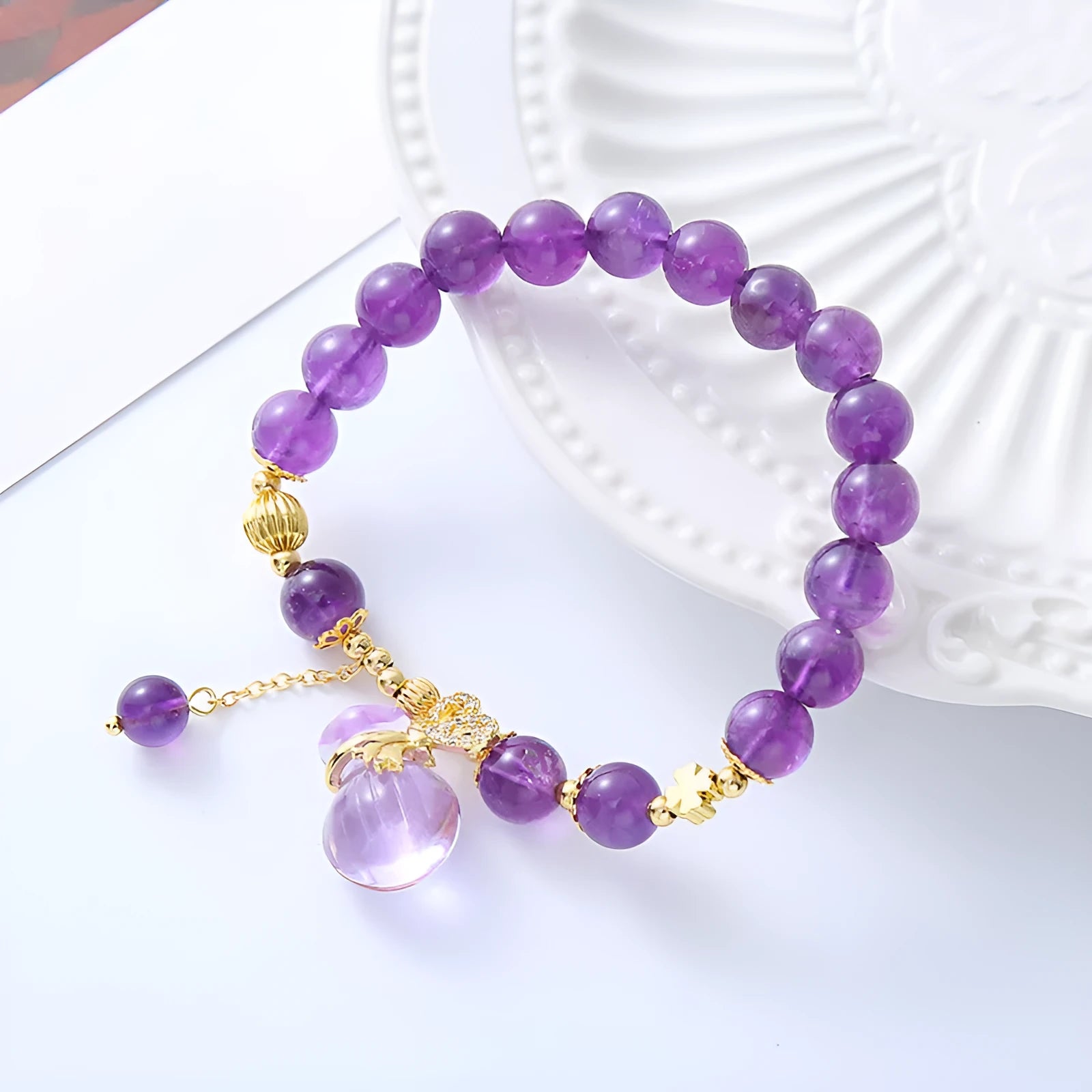 Purple amethyst bracelet with detailed money bag charm and peace buckle pendant on wrist
