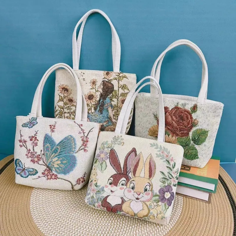 Gold wire embroidered canvas handbag showing bunny design, with polyester lining and top handles.
