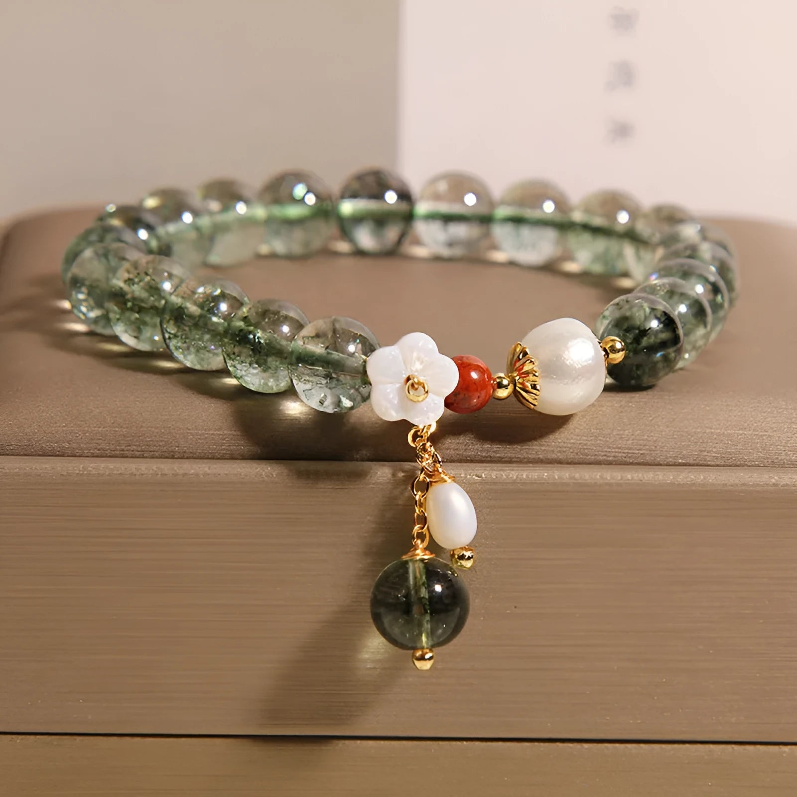 Green phantom quartz crystal bracelet with small bells of Ireland design and shell flower accents