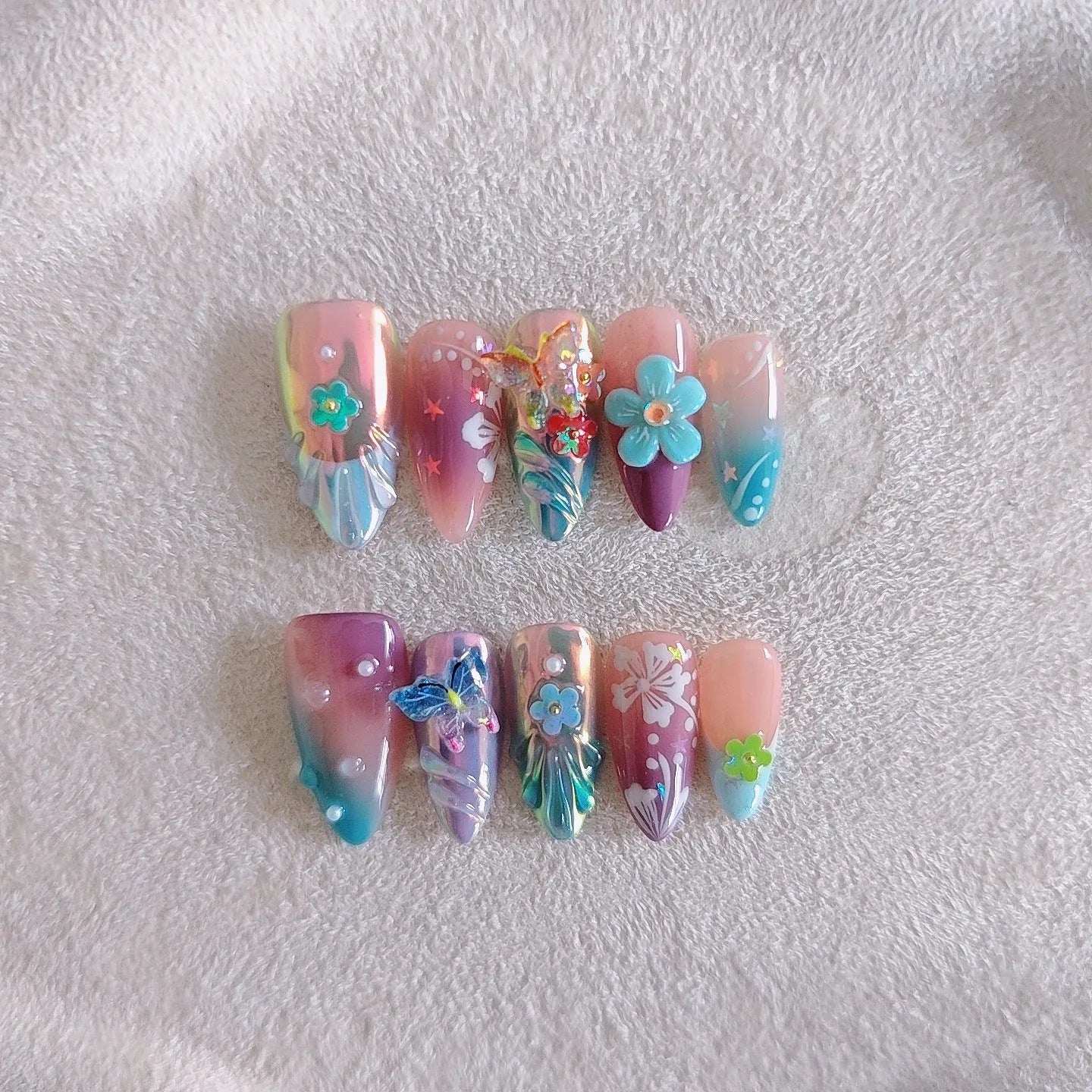 Handmade manicure sculptures showing embossed floral and butterfly patterns in four sizes (XS, S, M, L) for nail art