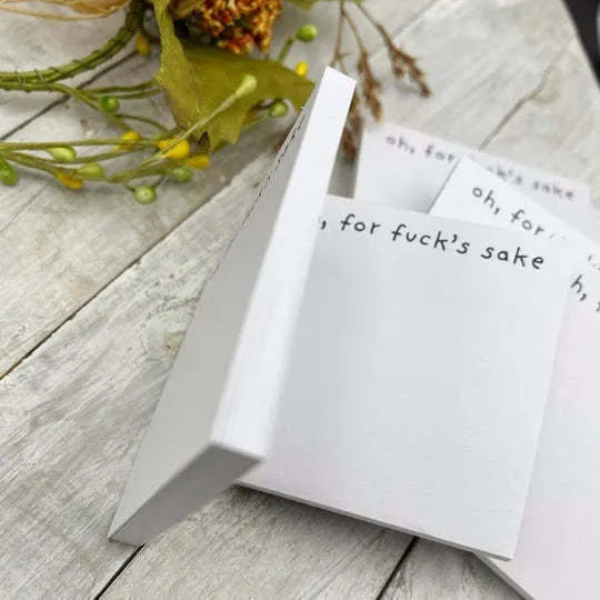 Square 7.5cm sticky note pad with adhesive strip and printed English text on cover.