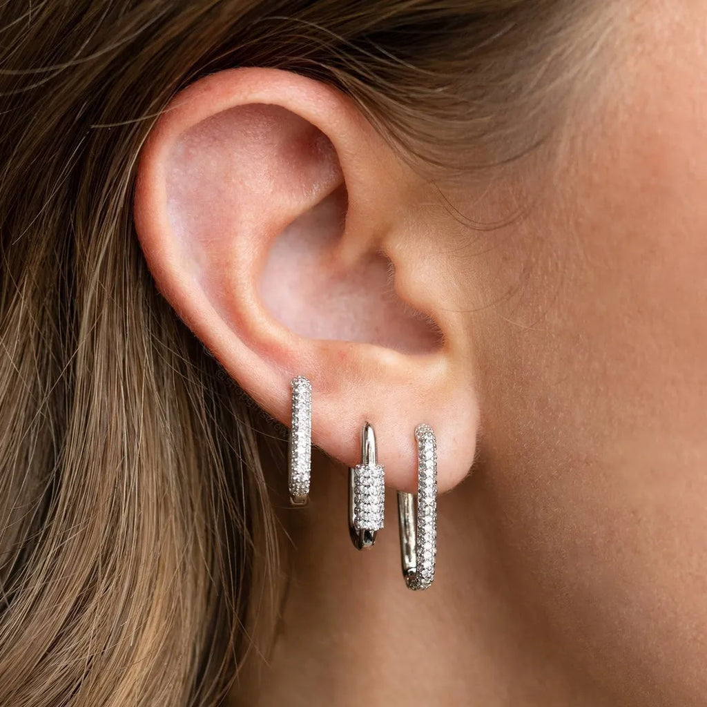 Three geometric copper ear clips with zircon detailing in ellipse and quadrilateral shapes on ear