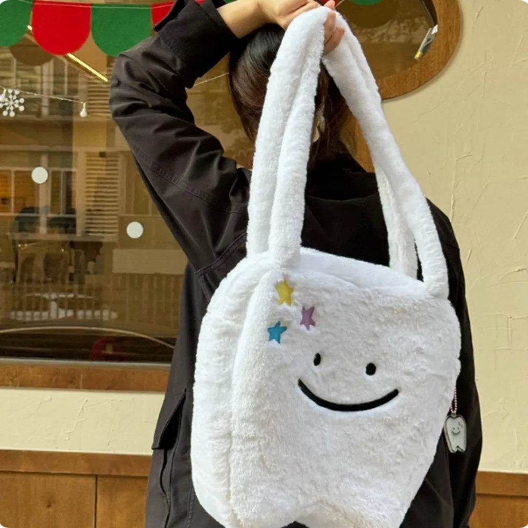 White plush tote bag with cute tooth graphic and a crossbody strap.