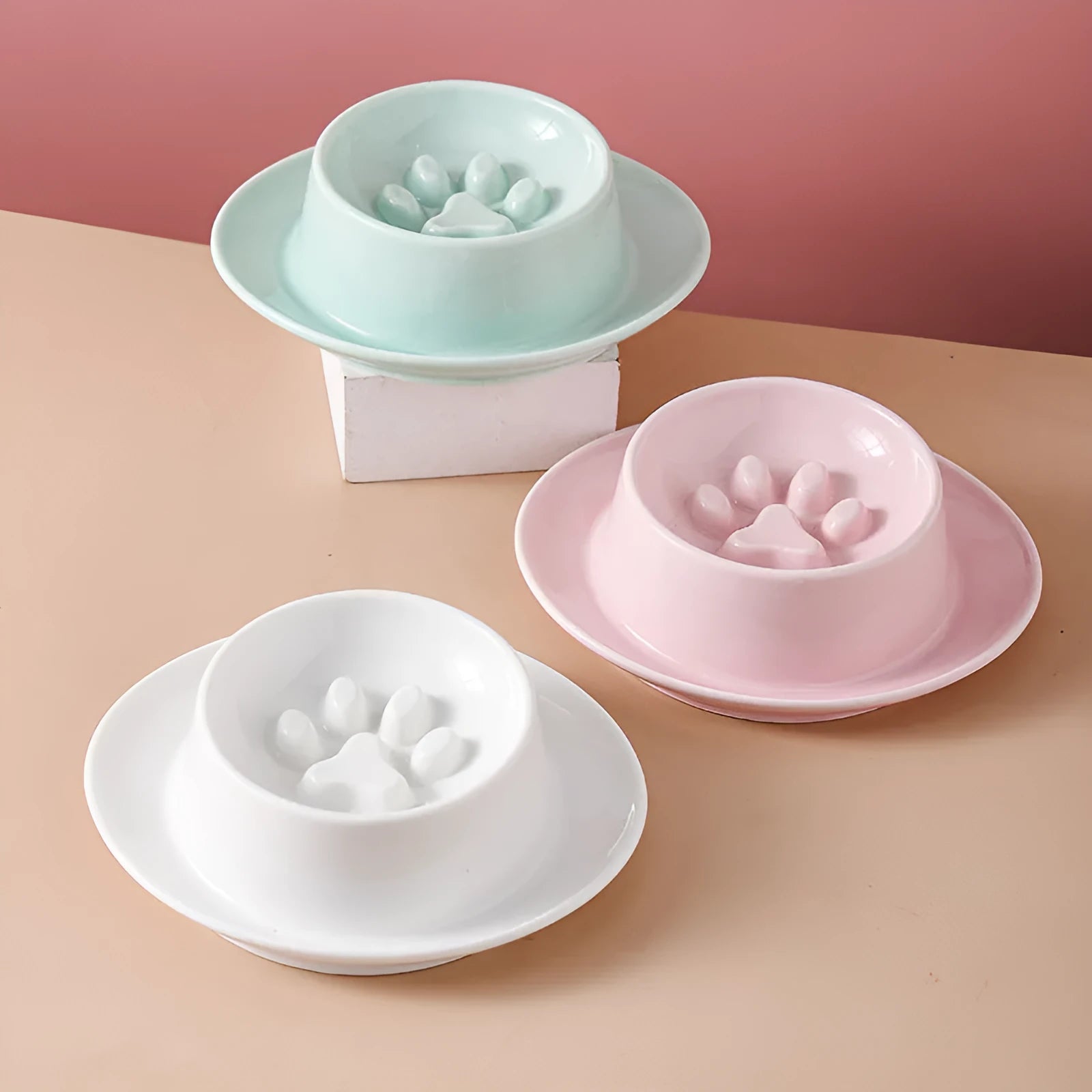 Green ceramic slow feeder pet bowl with maze pattern and non-slip silicone base on a kitchen floor.