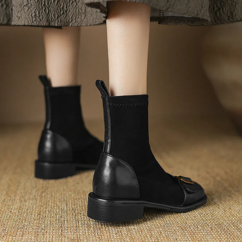 Women's black low heel Martin boots with lace-up front and belt buckle detail.