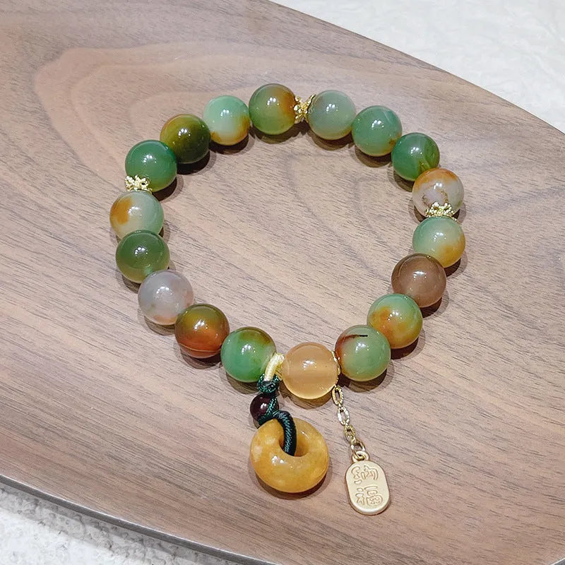 Yellow peacock agate and topaz bracelet with a peace buckle clasp and a lutong agate charm.