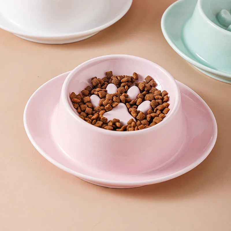 Green ceramic slow feeder pet bowl with maze pattern and non-slip silicone base on a kitchen floor.