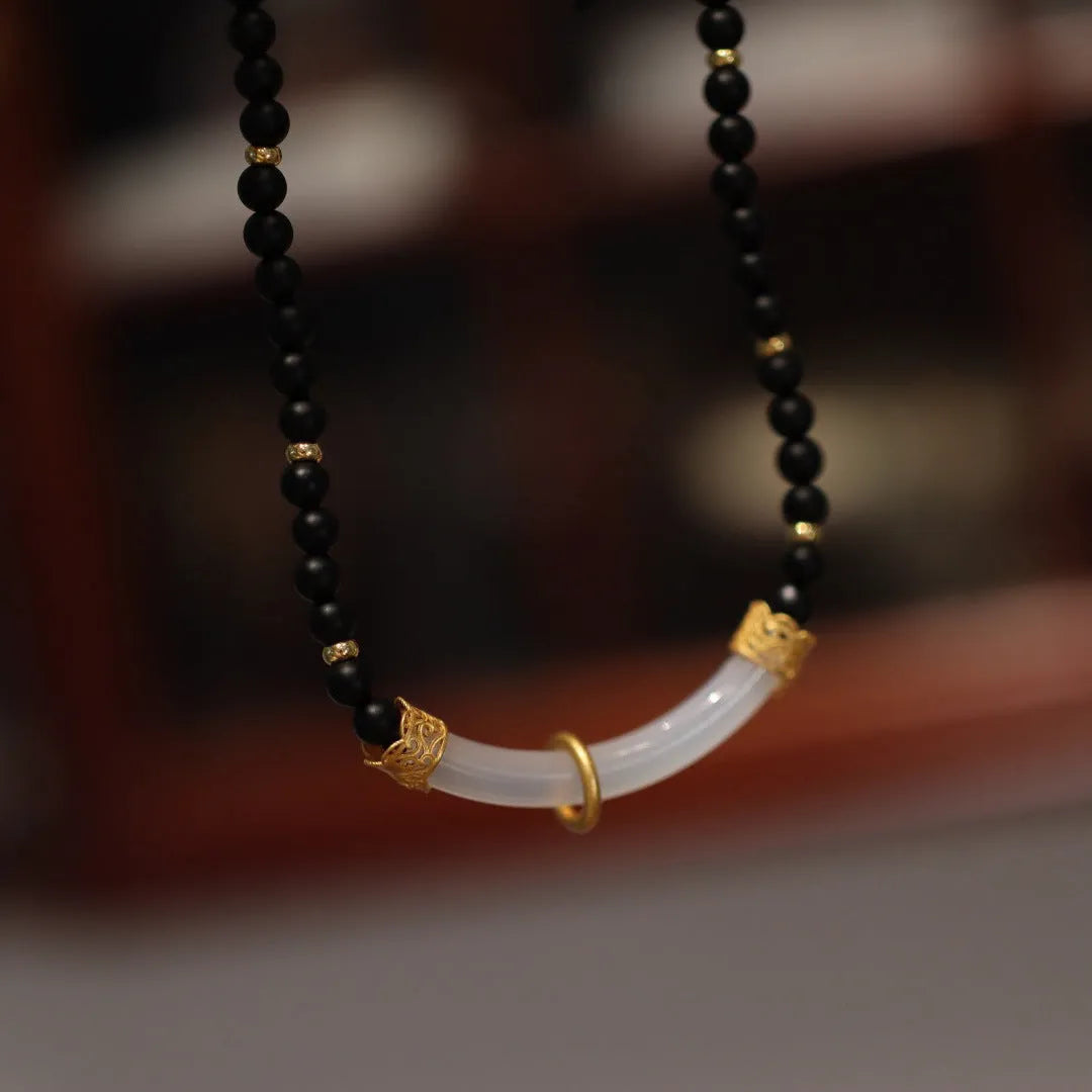Chinese style U-shaped frosted black agate and white chalcedony necklace on beaded silver chain.