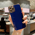 Gold-plated striped iPhone case on a phone, shown in white colour.