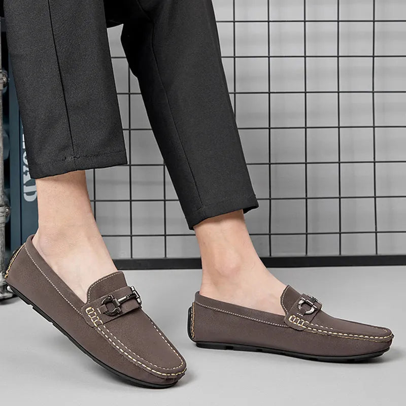 Men's beige slip-on loafers with a round toe and rubber sole on a plain background.