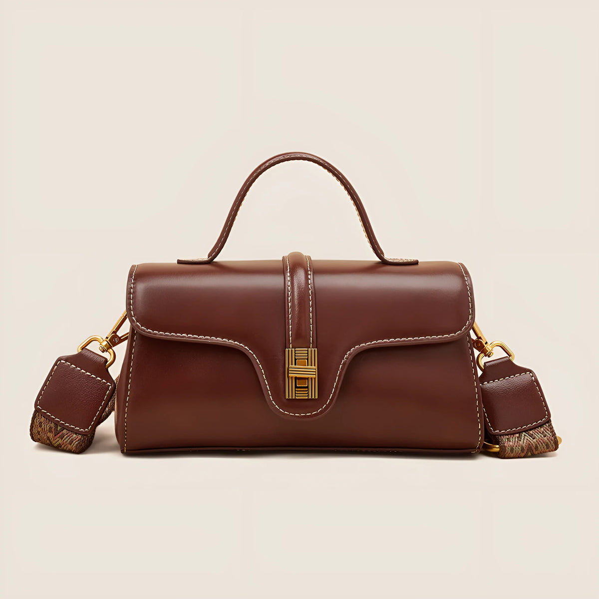 Brown Cambridge-style leather messenger bag with a front lock, shown open to reveal internal zipper pockets.