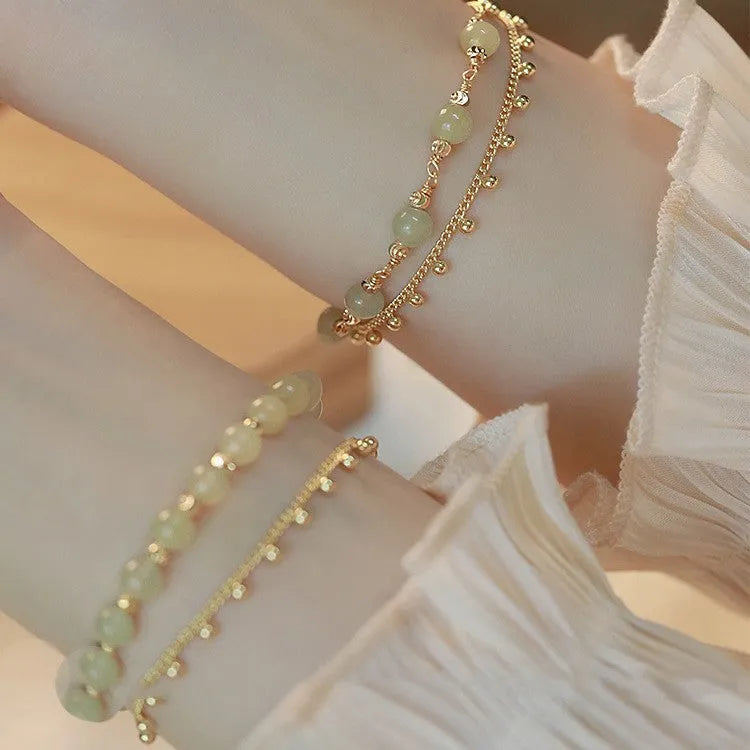 Natural Hetian Jade beaded bracelet with princess running motif on a wrist.