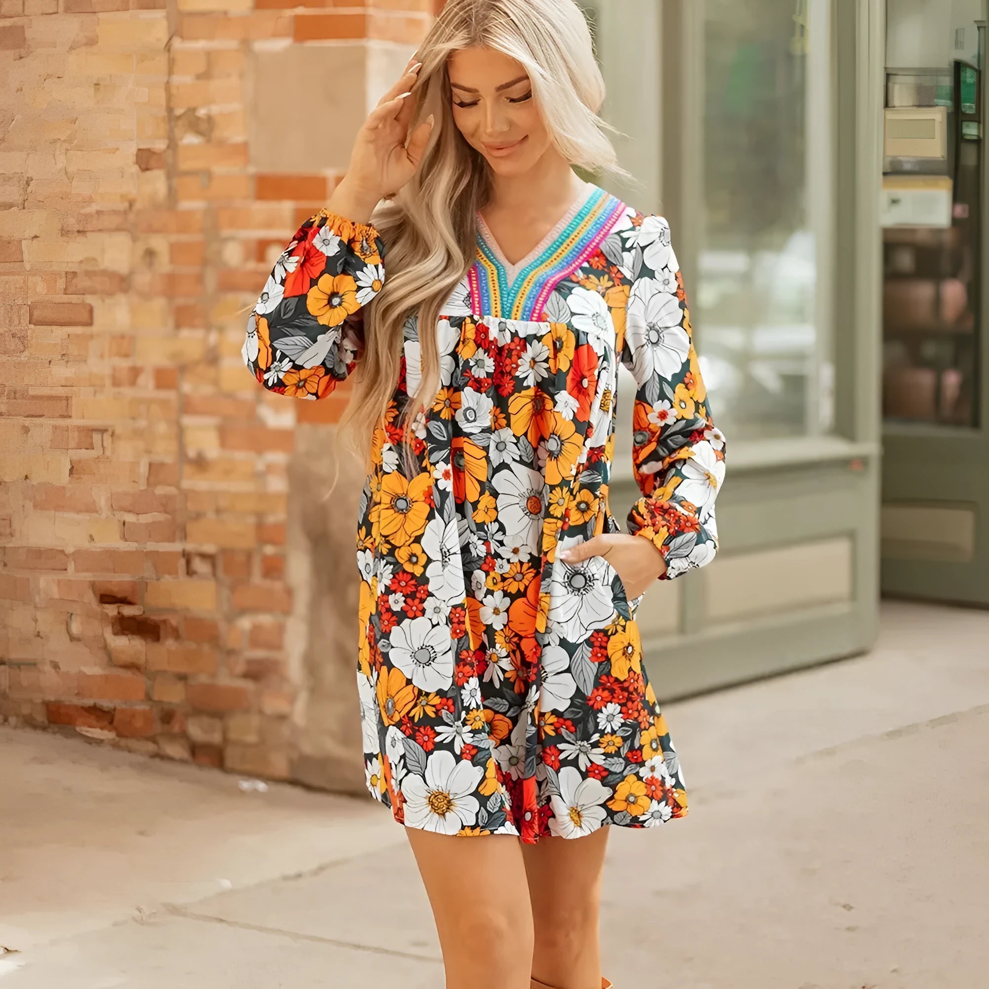 Orange floral and striped print long sleeve V-neck mini dress with lace detail on hanger.
