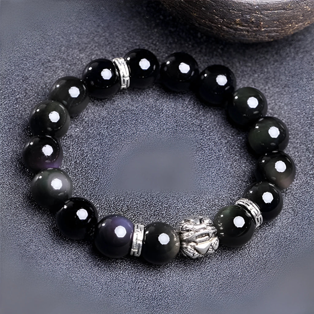 Natural obsidian and 999 silver unisex bracelet on a wrist, showing 10mm or 12mm bead size options.