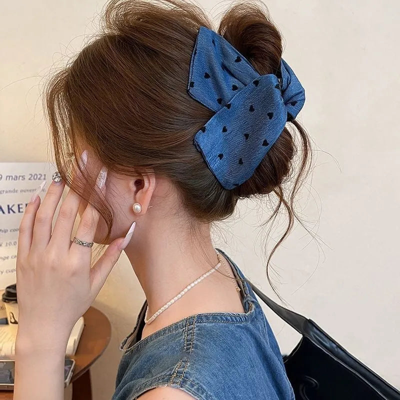 Handmade women's plastic hairpin with denim bow and triangular grip.