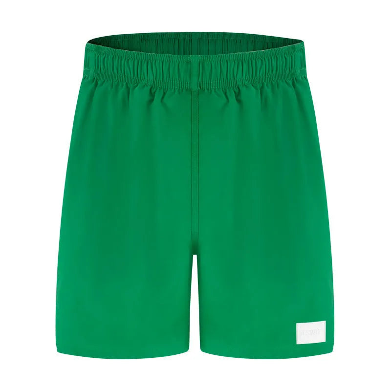 Men's solid colour quick-dry nylon shorts in green, shown with straight leg and elasticated waist.