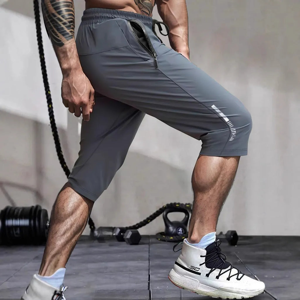 Men's cropped sports pants in blue with quick-drying nylon fabric and elastic waistband