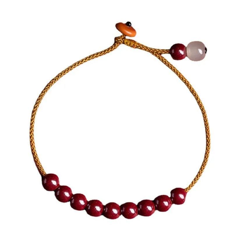Hand-woven bracelet made from raw cinnabar and Hetian jade beads in a geometric design.