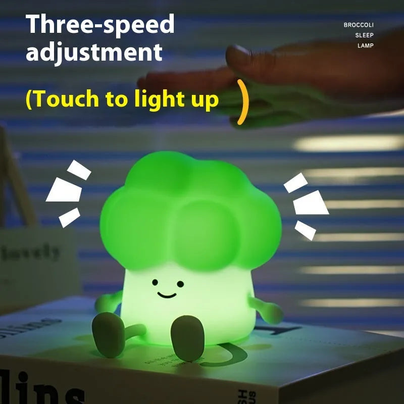 Cartoon-shaped eggplant night lamp glowing with soft yellow light on a table.